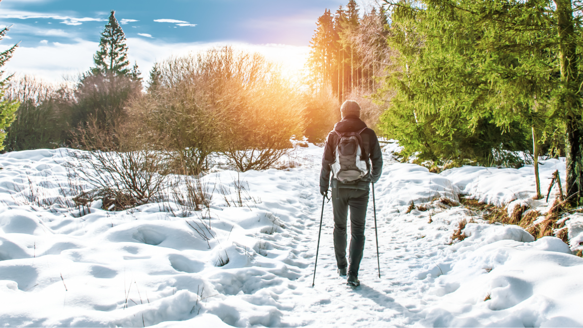 a man staying warm hiking in the winter 